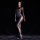 Woman modeling a shiny, sheer bodysuit with ultra-thin tights and open-crotch design, featuring a built-in sleeve for seducti...