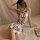 A woman poses elegantly in a vintage-inspired lace cheongsam dress featuring halter neck and side slit design, exuding retro ...