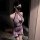 Woman modeling a purple vintage lace cheongsam lingerie set with sheer details, black bow, and fishnet stockings.