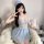 A woman poses playfully wearing a light blue luxury sheer lace babydoll set, featuring delicate lace details and a soft cap, ...