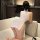 Woman in white open-front lace dress with high slit, posing on sofa; sexy tight-fit sleepwear for women.