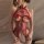Woman wearing a red sheer mesh halter lace bodysuit with intricate floral patterns and ribbon details.