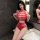 Woman wearing red sheer mesh bodysuit with lace cut-outs, tight-fit erotic lingerie set in bathroom setting.