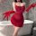 Woman in red yese yese lingerie dress with sheer mesh, corset bodice, and gloves, posing by bathtub.