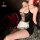 Woman in black mesh bodysuit with white lace apron, styled as seductive maid lingerie, beside red roses.