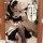 A woman wearing a black and white maid outfit, featuring a cute japanese lolita style dress with ruffles and stockings, posin...
