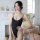 A woman poses in a black one-piece swimsuit with thin straps, featuring an open crotch design and high neck. the sleek, sheer...